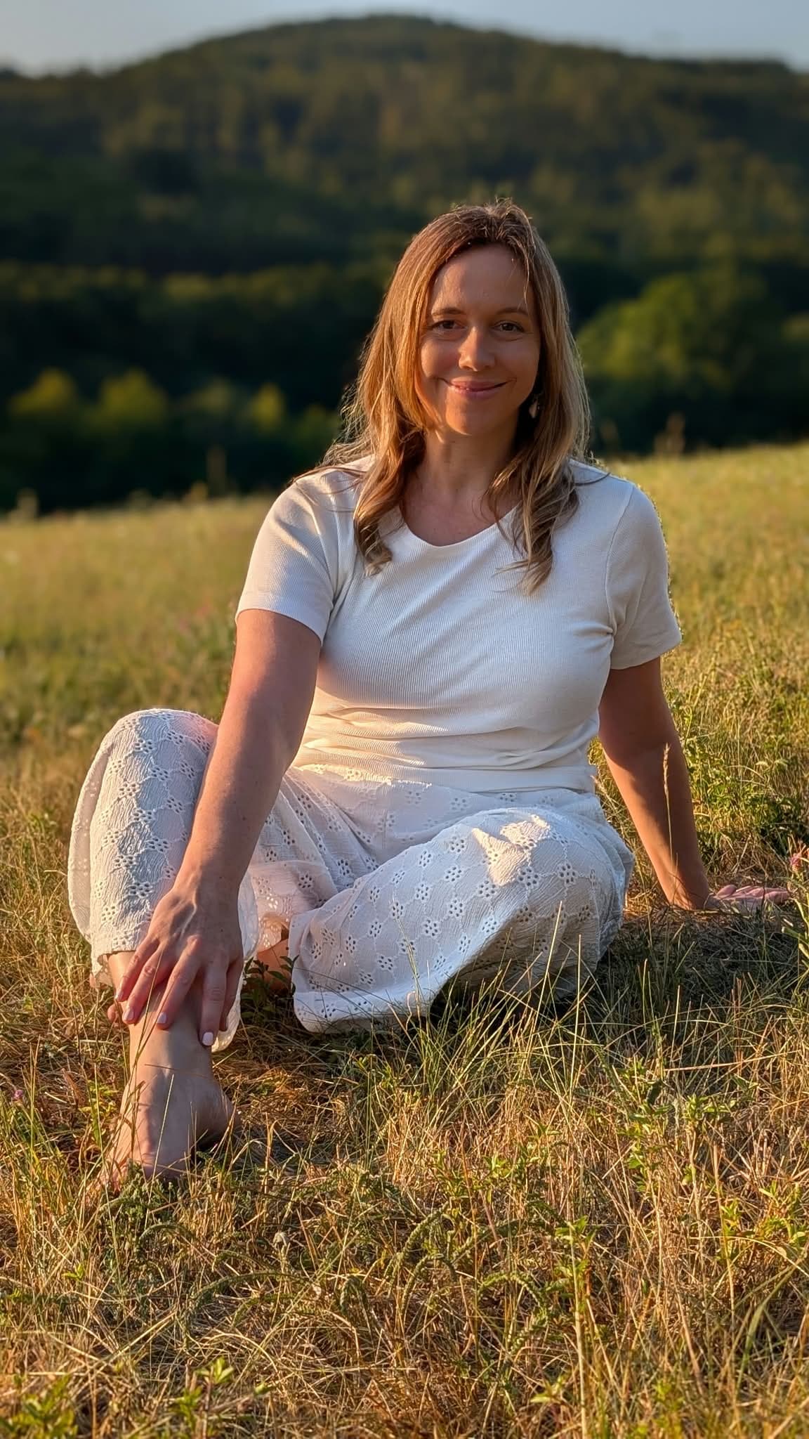 Ivana Černíková sedí na letní louce
