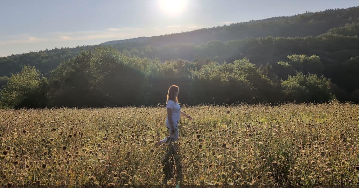 Ivana Černíková jde ranní loukou proti slunci